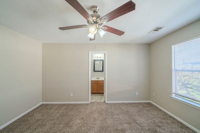 carpeted spare room with a textured ceiling, ceiling fan, and sink