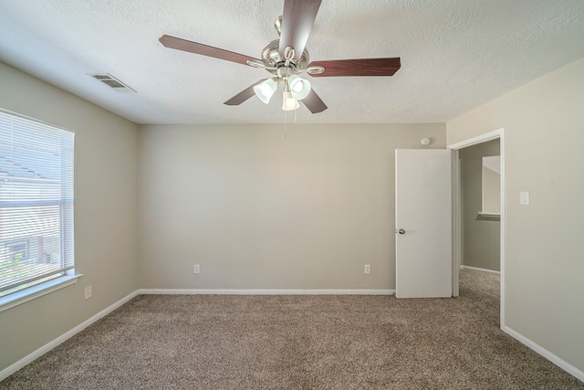 carpeted empty room featuring ceiling fan and a textured ceiling