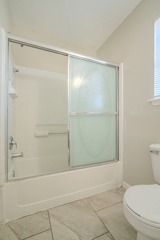 bathroom with toilet, tile patterned floors, shower / bath combination with glass door, and plenty of natural light