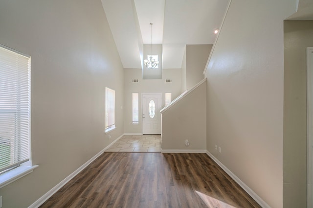 entryway with an inviting chandelier, dark hardwood / wood-style flooring, and a high ceiling