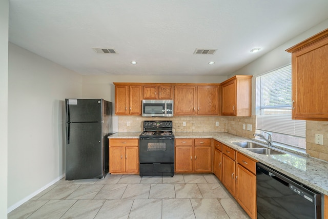 kitchen with light stone countertops, sink, backsplash, and black appliances