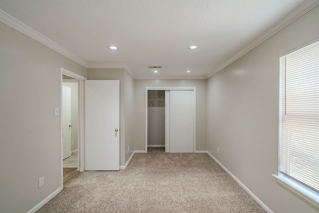 unfurnished bedroom with light carpet, a closet, and crown molding