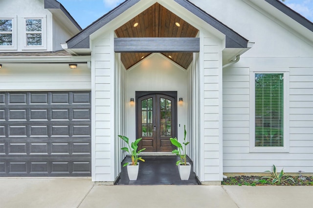 view of exterior entry featuring a garage and french doors