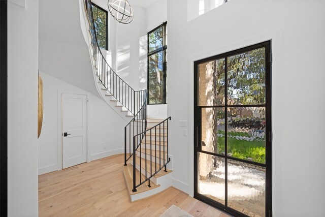 foyer entrance featuring light wood-type flooring and a chandelier