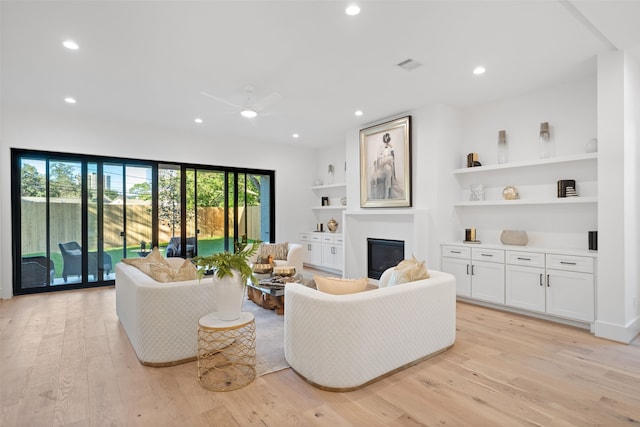 living room featuring ceiling fan and light hardwood / wood-style floors