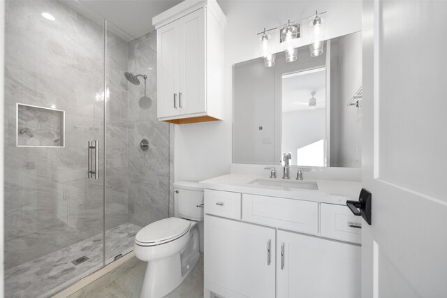 bathroom featuring toilet, tile patterned flooring, walk in shower, and vanity