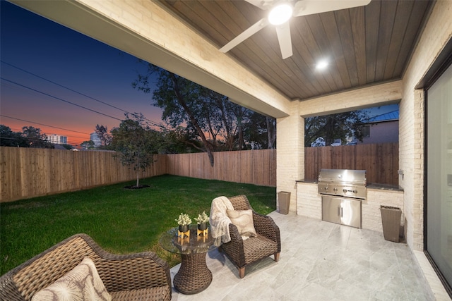 yard at dusk featuring ceiling fan