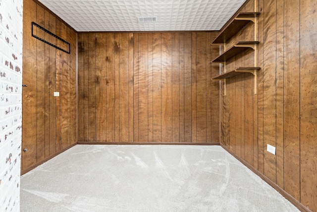 unfurnished room with wood walls and light carpet