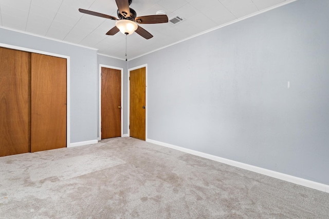 unfurnished bedroom with ceiling fan, ornamental molding, and carpet floors