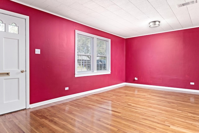 unfurnished room featuring ornamental molding and wood-type flooring