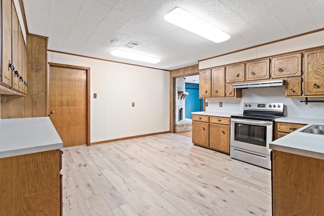 kitchen featuring sink, stainless steel electric range oven, light wood-type flooring, and crown molding