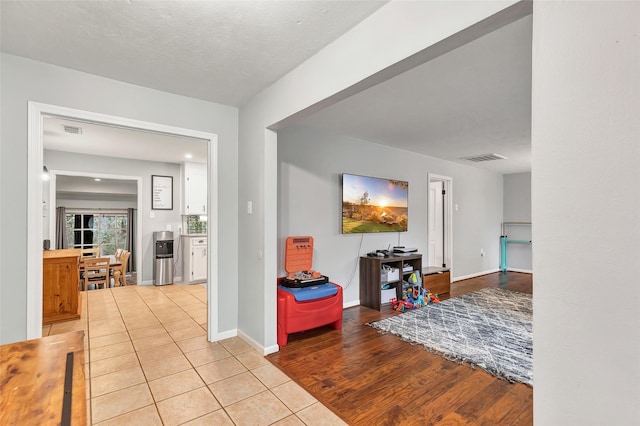 hall featuring a textured ceiling and light tile patterned floors