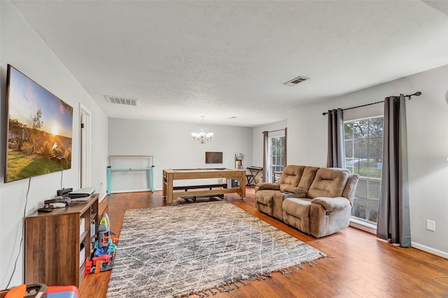 living room with hardwood / wood-style flooring and a notable chandelier