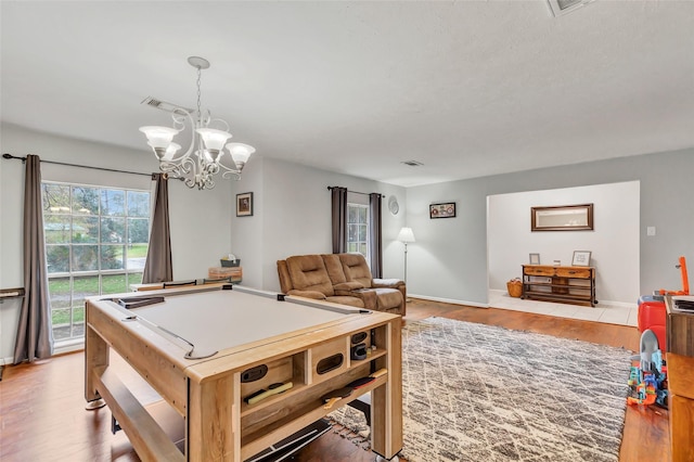 game room with a notable chandelier, billiards, and hardwood / wood-style floors