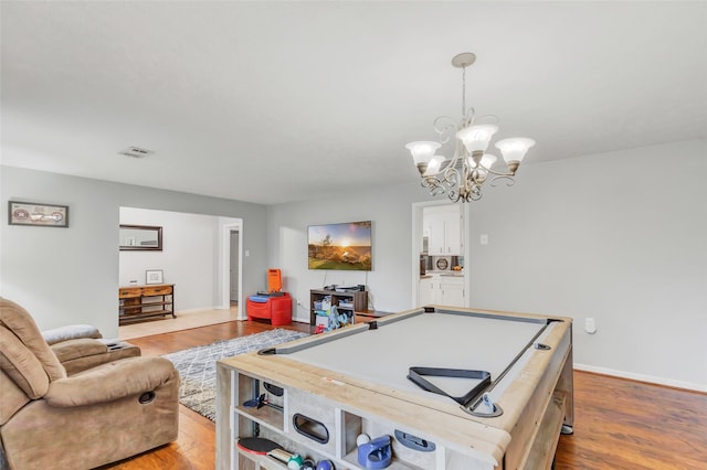 playroom featuring an inviting chandelier, light hardwood / wood-style floors, and billiards