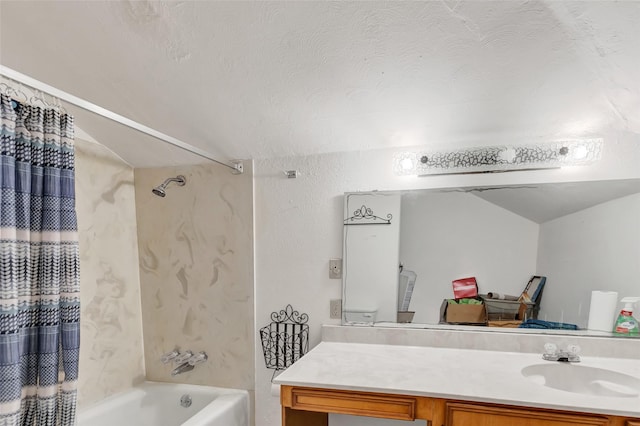 bathroom featuring a textured ceiling, vaulted ceiling, shower / bath combo, and vanity