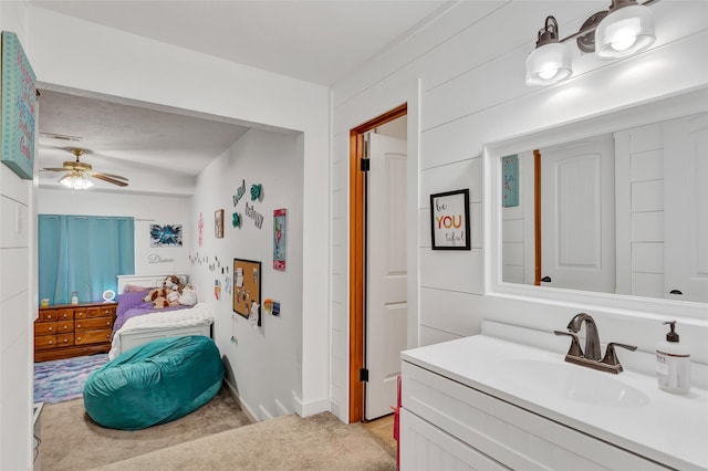 bathroom featuring vanity, wood walls, and ceiling fan