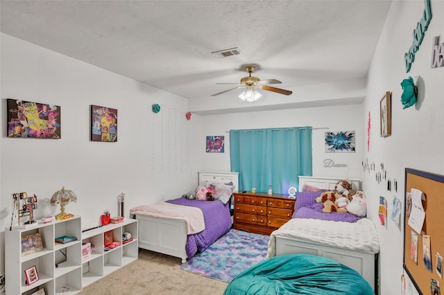 carpeted bedroom featuring a textured ceiling and ceiling fan