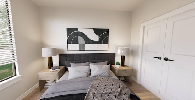 bedroom featuring a closet, multiple windows, and light wood-type flooring