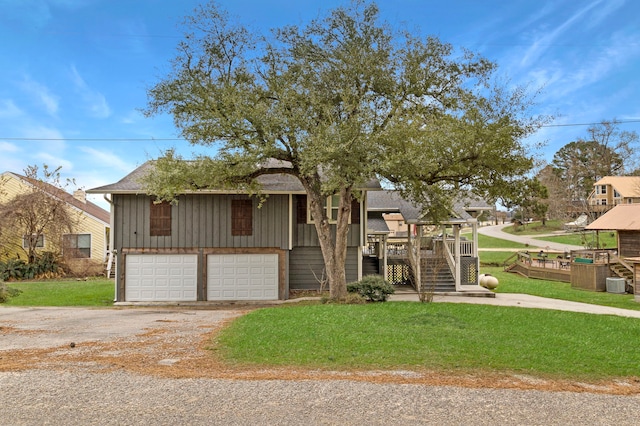 view of front of property featuring a front yard, cooling unit, and a garage