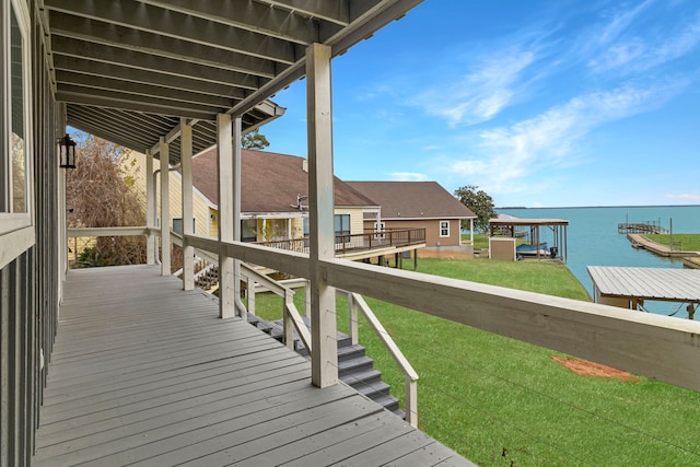 wooden terrace with a lawn and a water view