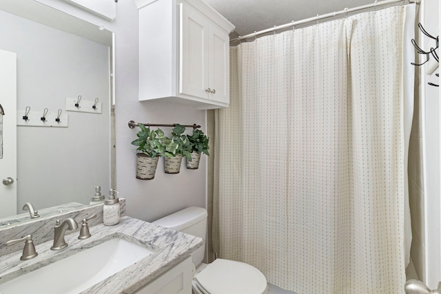 bathroom featuring toilet, vanity, and walk in shower