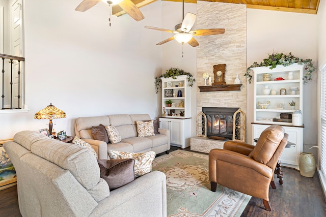 living room with ceiling fan, a fireplace, dark hardwood / wood-style floors, high vaulted ceiling, and wooden ceiling