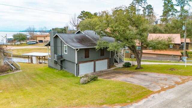 view of side of home with a lawn, central AC unit, and a garage