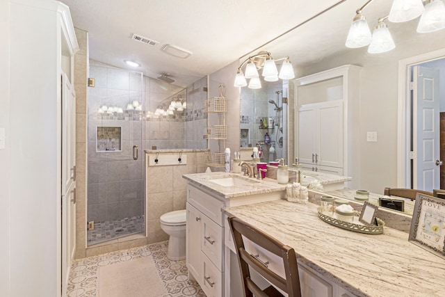 bathroom featuring vanity, toilet, a shower with shower door, and tile patterned flooring