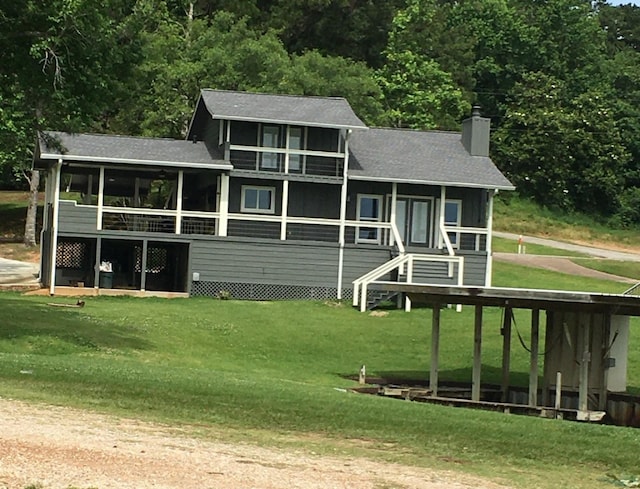 view of front of home featuring a front yard and a sunroom