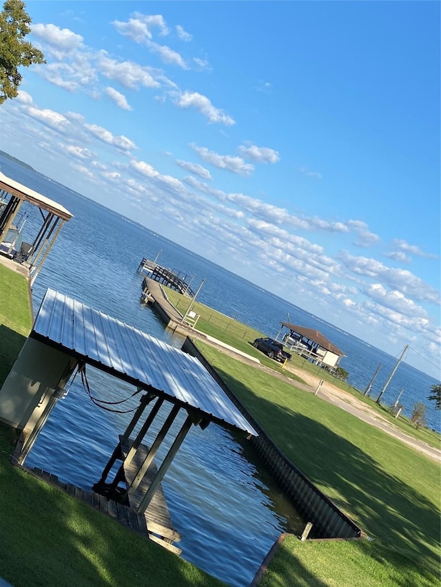 view of dock featuring a lawn and a water view