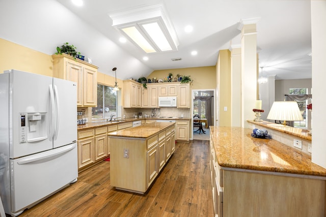 kitchen featuring sink, vaulted ceiling, white appliances, tasteful backsplash, and hanging light fixtures