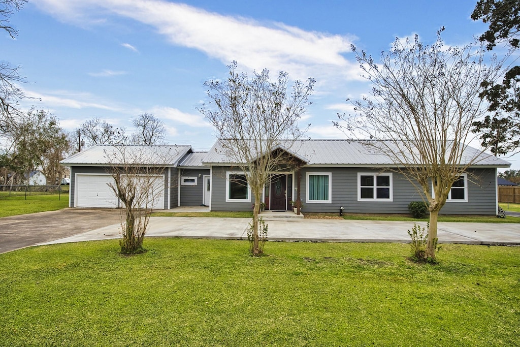 single story home featuring a front lawn and a garage