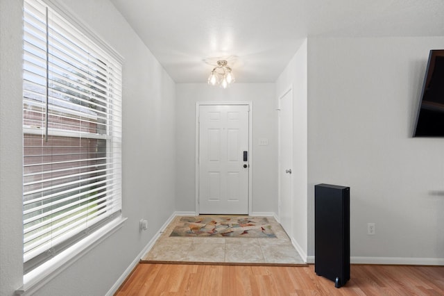 foyer with hardwood / wood-style flooring and a chandelier