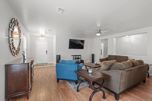 living room with ceiling fan and light hardwood / wood-style flooring