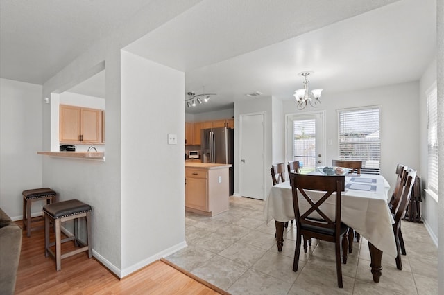 dining space with a notable chandelier and light tile patterned floors