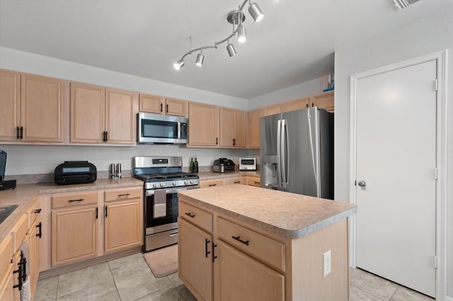 kitchen with light brown cabinetry, appliances with stainless steel finishes, light tile patterned floors, and a center island