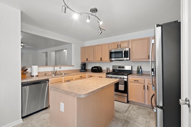 kitchen featuring stainless steel appliances, sink, a center island, light brown cabinets, and ceiling fan