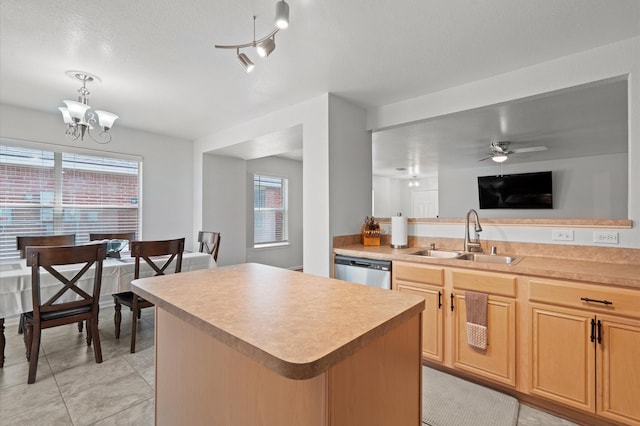 kitchen featuring hanging light fixtures, a kitchen island, sink, stainless steel dishwasher, and ceiling fan with notable chandelier