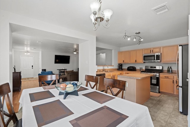 dining area featuring sink and ceiling fan with notable chandelier