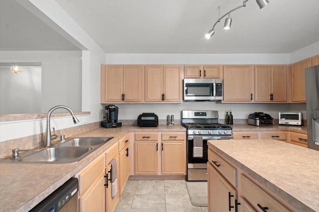 kitchen featuring sink, stainless steel appliances, light tile patterned flooring, and light brown cabinets