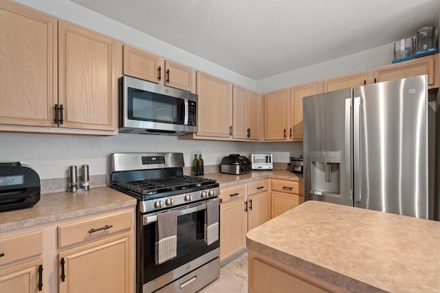 kitchen with light brown cabinets and appliances with stainless steel finishes