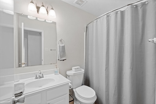 bathroom with curtained shower, vanity, and toilet