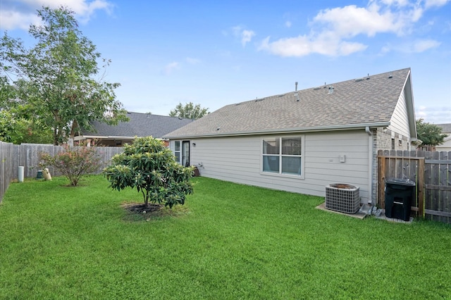 rear view of house featuring a yard and central air condition unit