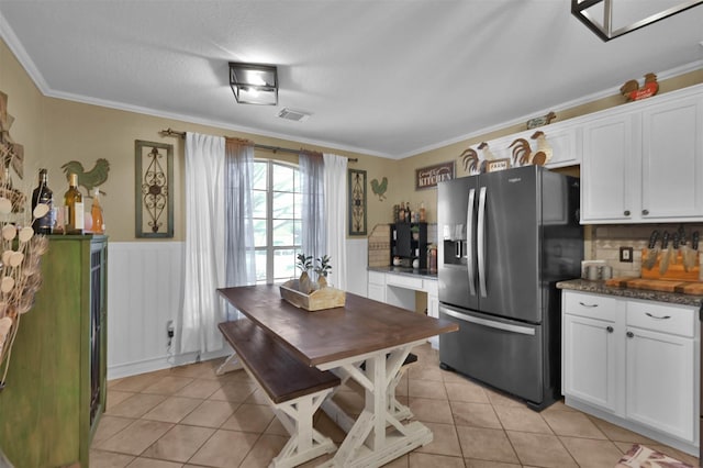 kitchen featuring white cabinets, light tile patterned floors, and stainless steel refrigerator with ice dispenser