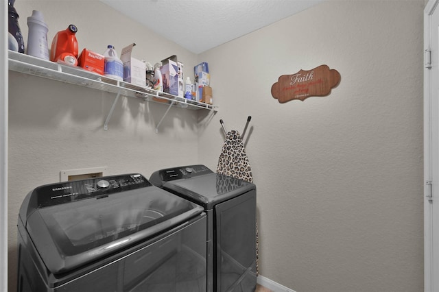 washroom with a textured ceiling and washer and clothes dryer