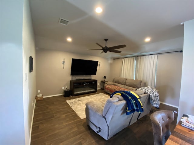 living room with ceiling fan and dark wood-type flooring