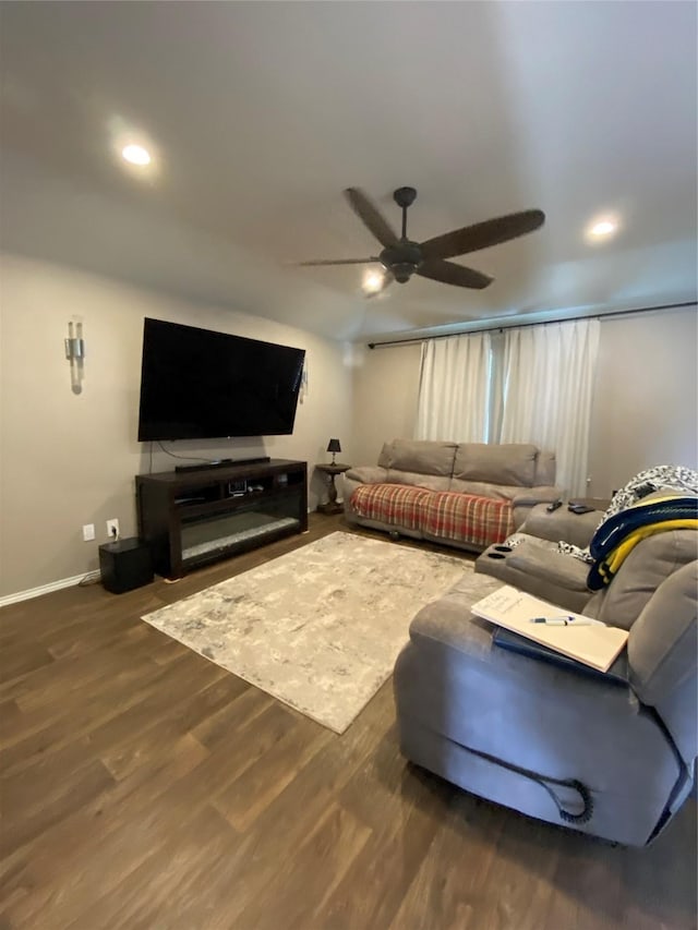 living room featuring ceiling fan and dark wood-type flooring