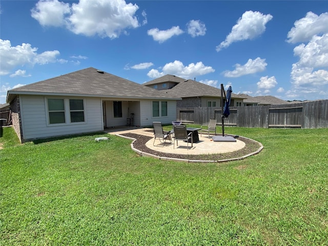 rear view of house with a yard and a patio