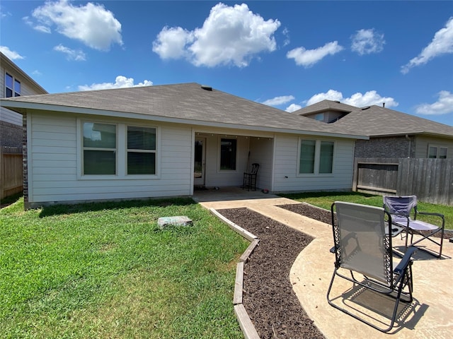 back of property with a patio area and a yard